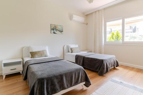 イズミールにあるComfortable and new apartment near the sea!のベッド2台と窓のある寝室