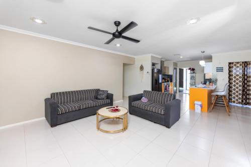 a living room with two couches and a ceiling fan at Holiday Home in Branxton