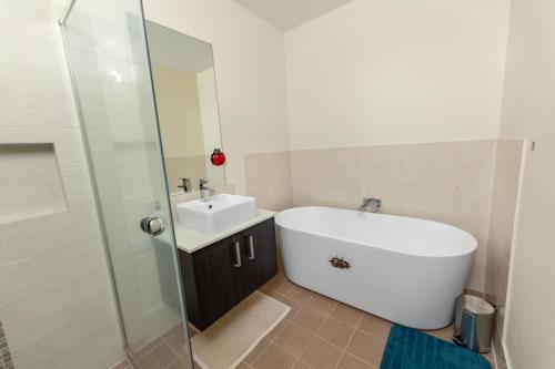 a bathroom with a tub and a sink and a shower at Holiday Home in Branxton