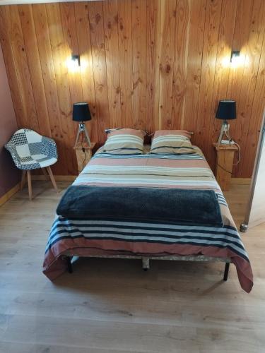un lit dans une chambre avec un mur en bois dans l'établissement La Ferme du Panorama et Spa, à Ventron