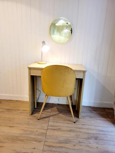 - un bureau avec une chaise, une lampe et un miroir dans l'établissement Le Mathurin - deux pièces à deux pas de l'éléphant, à Nantes