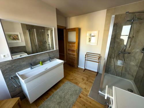 a bathroom with a tub and a sink and a shower at Ferienwohnung Fläming in Bad Belzig