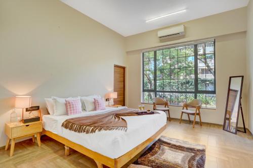 a bedroom with a large bed and a large window at ELIVAAS Villa 39 - Serene 6 BHK Retreat with Pvt Pool, Gaming Zone & Balcony in Lonavala