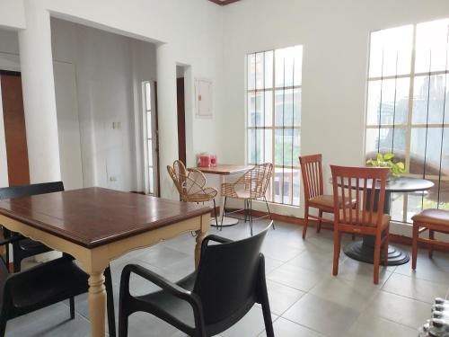 a dining room with tables and chairs and windows at R & J Homestay in Naga Cebu in Tina-an