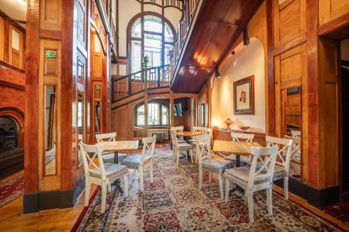 a dining room with wooden walls and tables and chairs at Vila Camelia in Sinaia