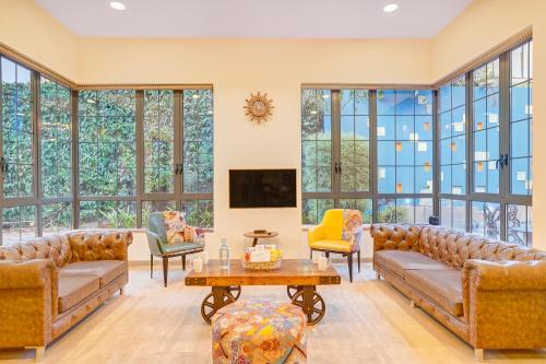 a living room with couches and a tv at ELIVAAS Villa 39 - Serene 6 BHK Retreat with Pvt Pool, Gaming Zone & Balcony in Lonavala