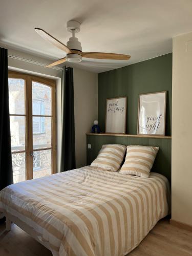 une chambre avec un lit avec un ventilateur de plafond dans l'établissement Cozy Appartment Champollion 1, à Figeac