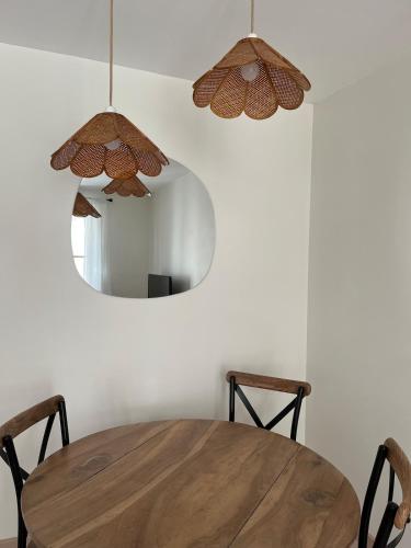 une table de salle à manger avec deux chaises et un miroir dans l'établissement Cozy Appartment Champollion 1, à Figeac