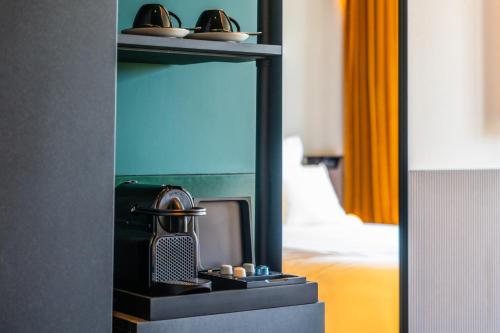 a mirror reflection of a hotel room with a coffee maker at TRIBE Paris Clichy in Clichy