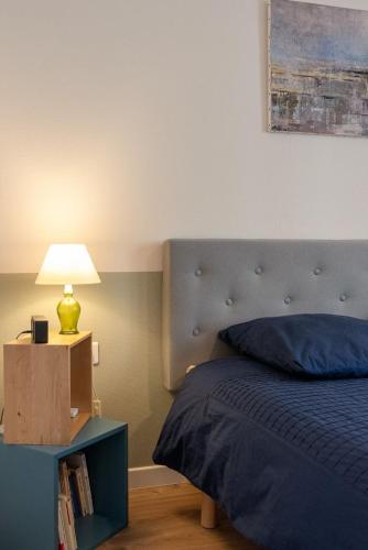 - une chambre avec un lit et une lampe sur une table de chevet dans l'établissement T2 Écrin de ville, à Toulouse