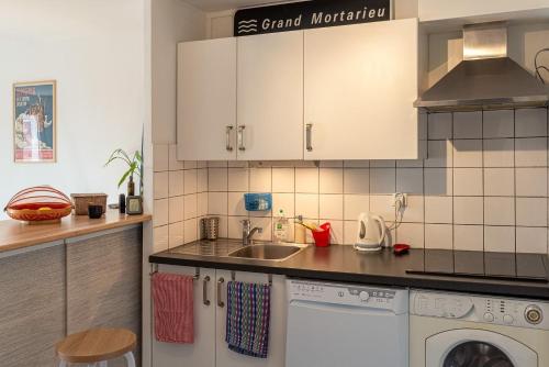 une cuisine avec un évier et une machine à laver dans l'établissement T2 Écrin de ville, à Toulouse