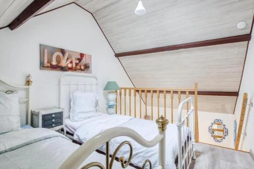 2 camas individuales en una habitación con techo en Appartement cosy à Sainte-Marie-du-Mont avec jardin 25m², en Sainte-Marie-du-Mont
