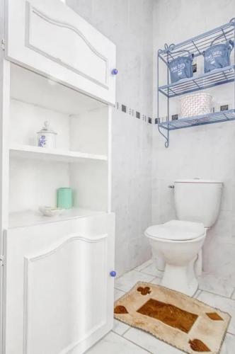 - une salle de bains blanche pourvue de toilettes et d'un tapis dans l'établissement Appartement cosy à Sainte-Marie-du-Mont avec jardin 25m², à Sainte-Marie-du-Mont