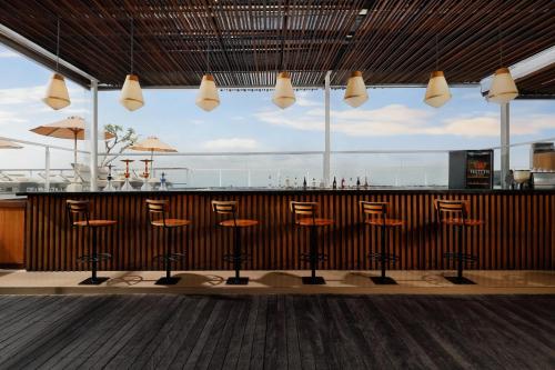 a bar with stools in front of a counter at Aston Canggu Beach Resort in Canggu