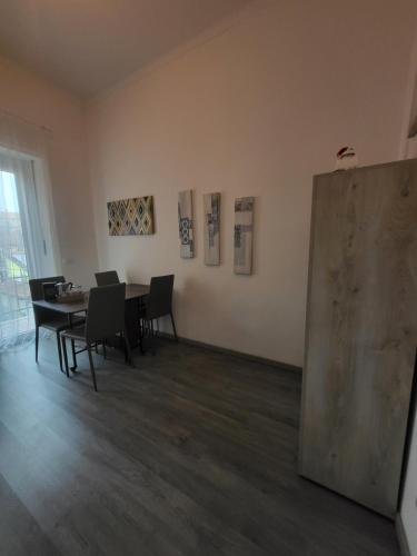 a room with a table and chairs and paintings on the wall at Fidia a pochi passi dalla metro in Turin