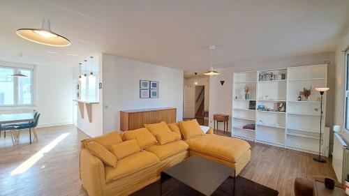 un salon avec un canapé jaune dans une pièce dans l'établissement Istanbul - Grand appartement en duplex, à Reims