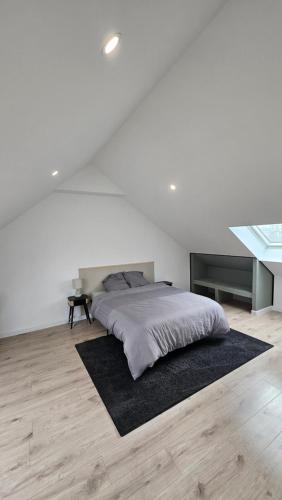 - une chambre blanche avec un lit et un tapis noir dans l'établissement Maison La Valenciennoise, à Valenciennes