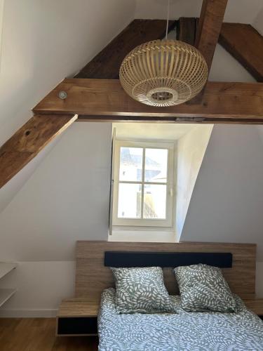- une chambre avec un lit, une fenêtre et un plafond dans l'établissement Le Pomerol apartment, à Château-Gontier