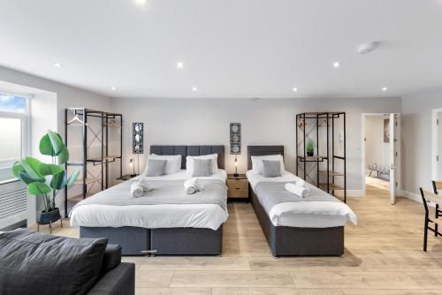 a bedroom with two beds and a couch at Warm & Bright Studio, Easy Commute to Central in New Southgate