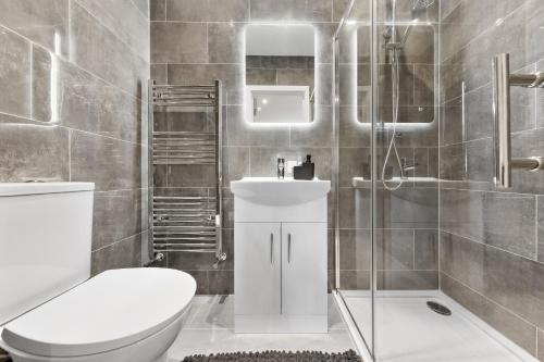 a bathroom with a toilet and a sink and a shower at Warm & Bright Studio, Easy Commute to Central in New Southgate