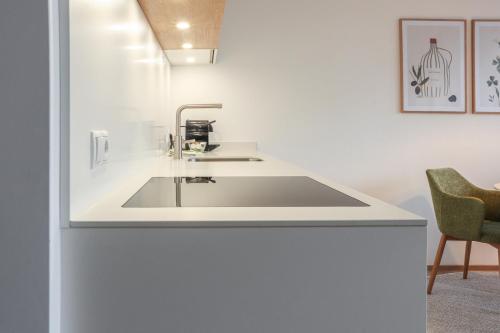 a kitchen with a sink in a white wall at Säntisblick Apartment in Schwarzach