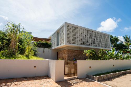 a house with a white fence in front of it at Duna Sonambula in Praia do Tofo