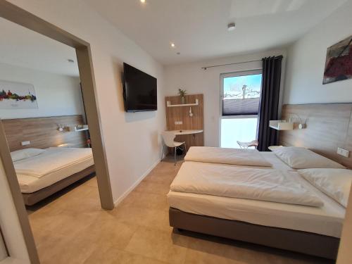 a hotel room with two beds and a mirror at NOVALIS Hotel by AURUM Dresden in Dresden