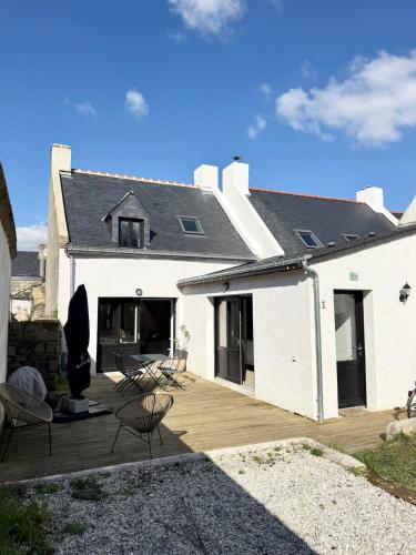 une maison blanche avec une terrasse en bois et des chaises dans l'établissement Maison de charme rénovée- Jardin - 5min des plages, à Arzon