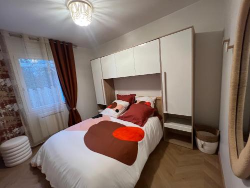 ein Schlafzimmer mit einem großen weißen Bett und roten Kissen in der Unterkunft Sweet Home Two in Saint-Jean-de-Monts