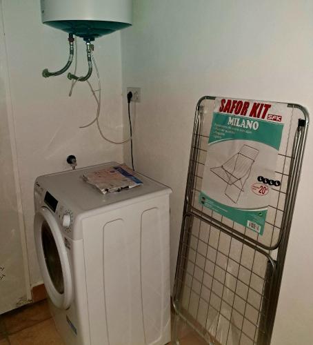 a washing machine in a bathroom with a sign on it at M&M Arboleas in Arboleas