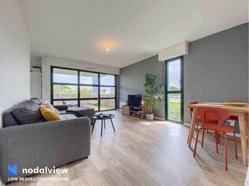 un salon avec un canapé et une table dans l'établissement Appartement au bord du lac, à Tours