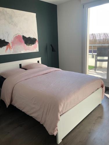 un lit dans une chambre avec un tableau sur le mur dans l'établissement La Terrasse, à Strasbourg