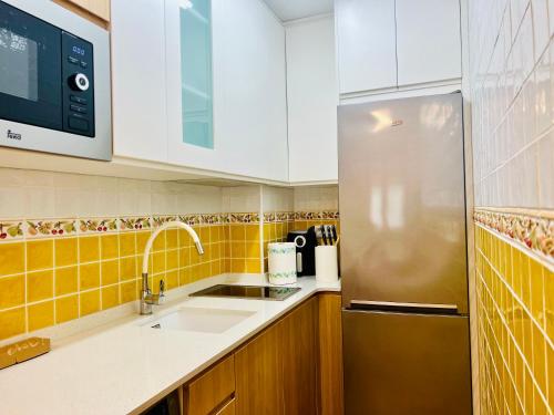 a kitchen with a sink and a refrigerator at Apartamento Acogedor con Vistas Espectaculares en Liébana, Picos de Europa in Camaleño