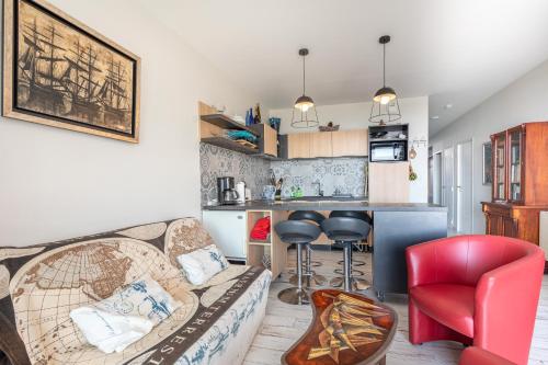 a living room with a couch and a kitchen at Le Rêve les Pieds dans l'eau in La Tranche-sur-Mer