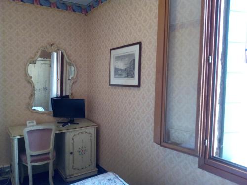 a room with a desk with a computer and a mirror at Panada A & P in Venice