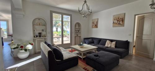 un salon avec un canapé bleu et une table dans l'établissement L'Horizon D'Azur, à Roquebrune-sur Argens