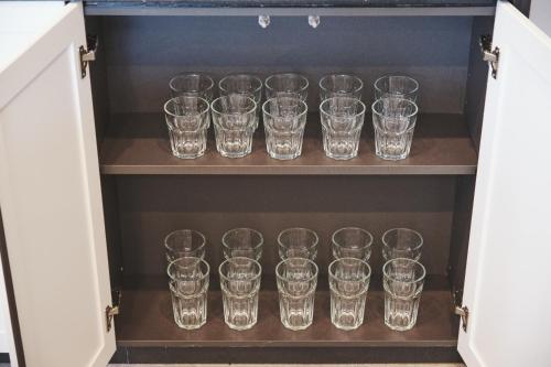 a cupboard filled with lots of empty glasses at Little Deer by SANA in Tateyama