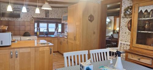 une grande cuisine avec des placards en bois et une table dans l'établissement La Maison Jaune, à Vendenheim