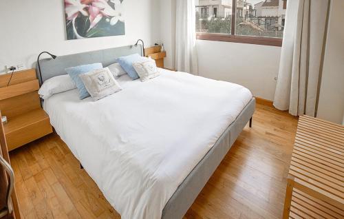 ein Schlafzimmer mit einem großen Bett mit weißer Bettwäsche und blauen Kissen in der Unterkunft Casa Rural Suite La Algara in El Ronquillo