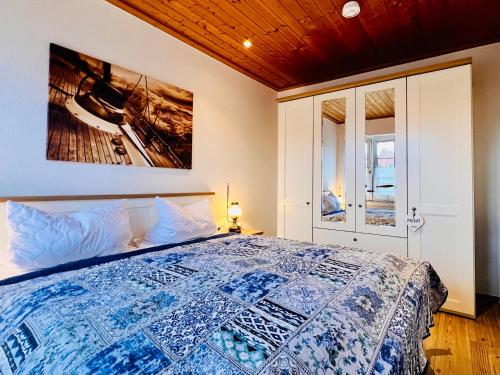 una camera da letto con un letto e un quadro sul muro di Ferienwohnung Veras Kate a Greetsiel