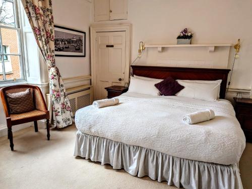 チチェスターにあるGeorgian House - Great for Groups & Celebrations! Located in Central Chichester with Parking - Chichester Holiday Propertiesの大きなベッドと椅子のある寝室