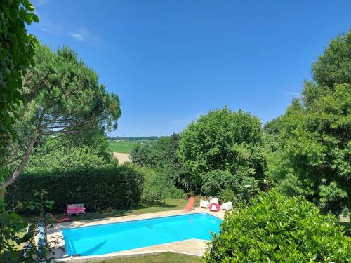 une piscine dans un jardin arboré dans l'établissement Maison de Charme, à Saint-Georges-des-Agoûts