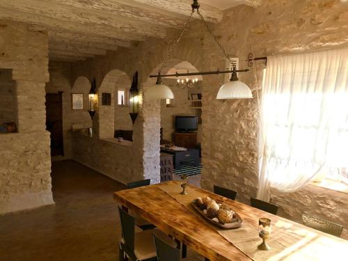 a dining room with a wooden table and a kitchen at Riad Pura Vida II in Essaouira