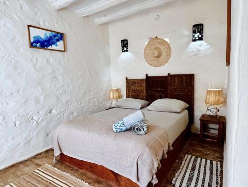 a bedroom with a bed in a room with white walls at Riad Pura Vida II in Essaouira