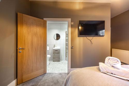 a bedroom with a bed and a television on the wall at Sandbed in Hawick