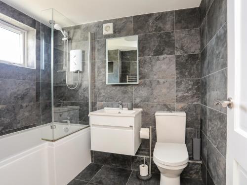 a bathroom with a toilet and a sink and a tub at Glan Y Don Bach in Abersoch
