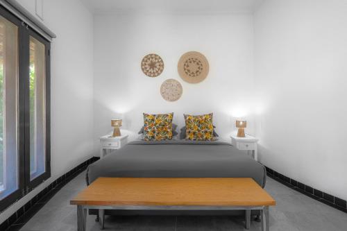 a bedroom with a bed and a table at Asri Villas Bingin in Uluwatu