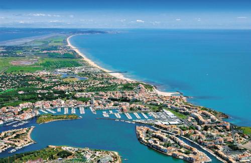 an aerial view of a harbor next to a beach at Le Cap'tivant in Cap d'Agde