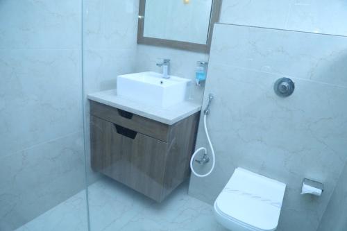 a bathroom with a sink and a toilet and a shower at Geetanjali International Annex a unit of Geetanjali International in Deoghar