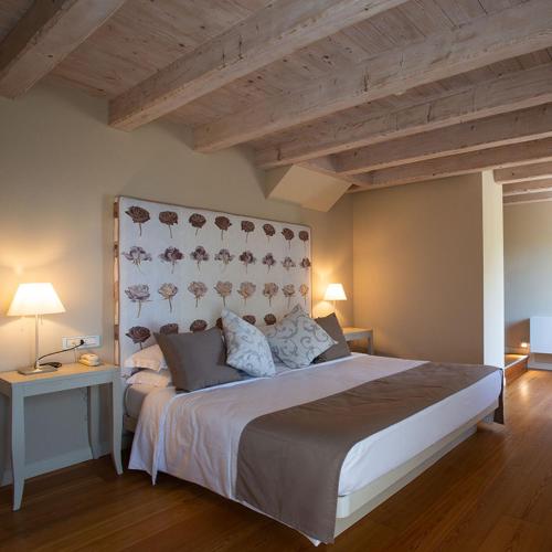 a bedroom with a large bed with a wooden ceiling at Locanda La Candola in Farra di Soligo